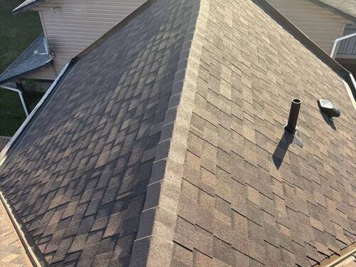 Full Roof Replacement — Finished roof from the ground — clean lines and tight cut-ins at the hips.