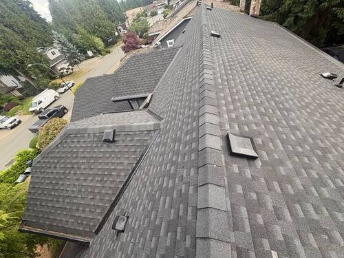 Full Roof Replacement — Close-up of the new grey architectural shingle course and ridge line.