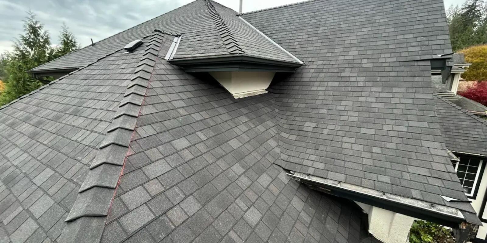Crew tearing off storm-damaged shingles during a full reroof in Maple Ridge, BC