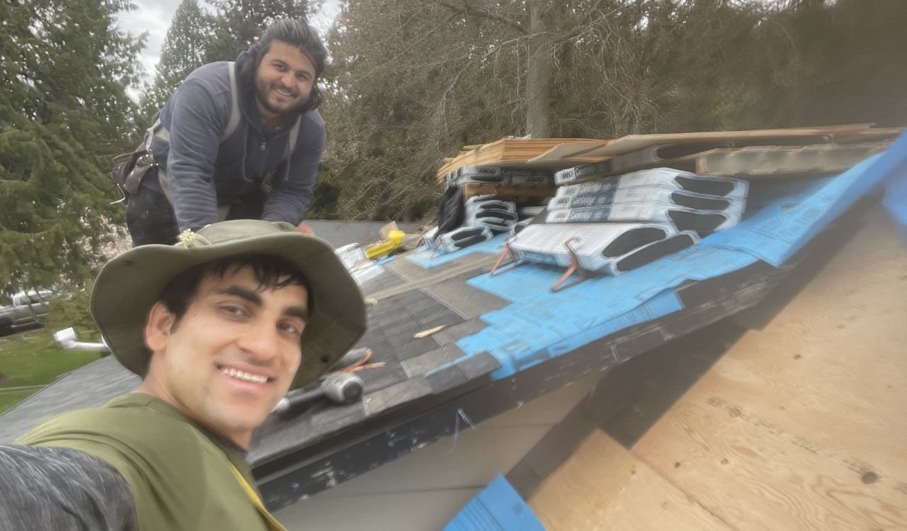 Roofer inspecting a residential asphalt shingle roof in Metro Vancouver